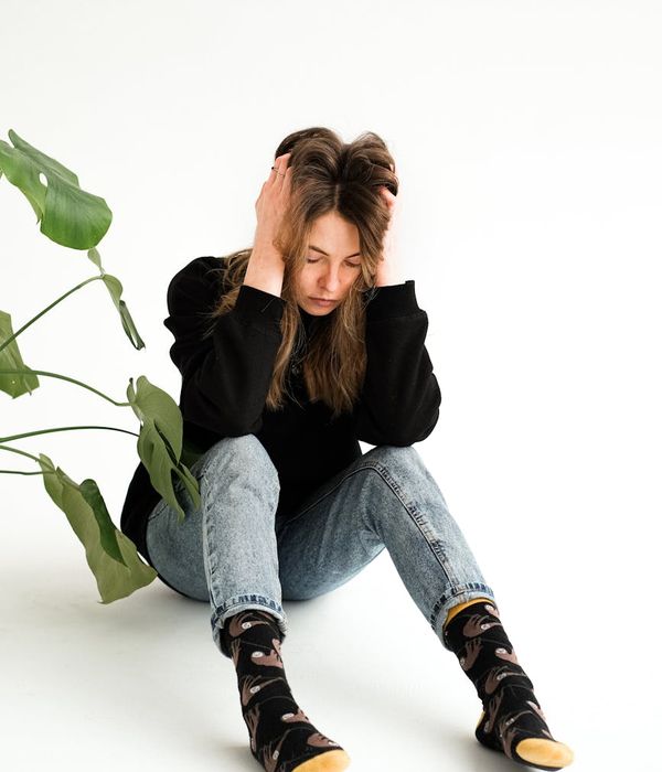Woman sitting in a serene meditative lotus pose in a calm room.